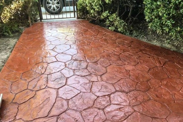 Entrada de jardín con hormigón impreso en molde piedra irregular terracota en Vitoria