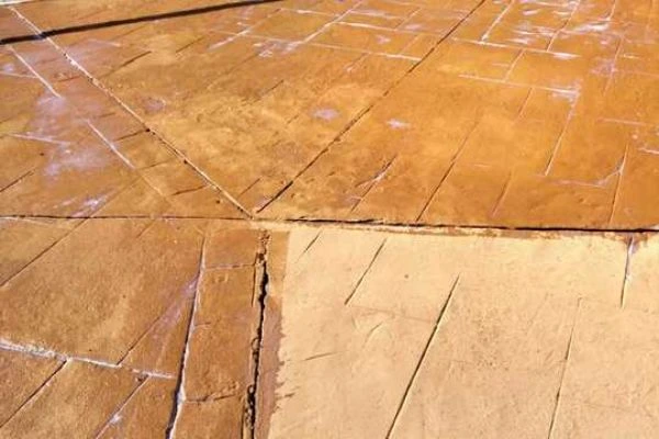 Grieta en pavimento de hormigón impreso terracota en proceso de reparación en Álava